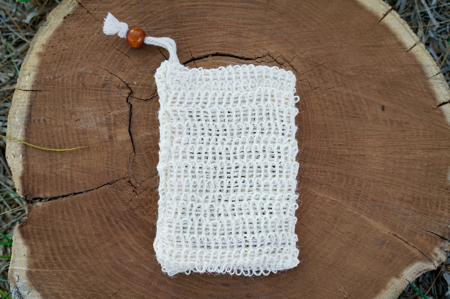 Sisal soap saver bag on a wood log